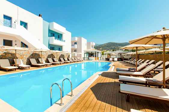 Udendørs swimmingpool og liggestole ved hotelbygning. (AI-genereret tekst)