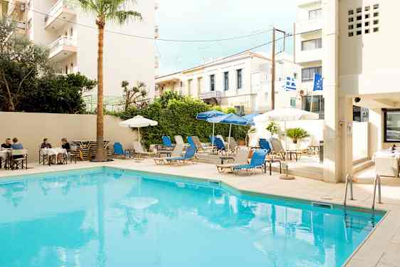 En udendørs swimmingpool omgivet af liggestole og parasoller. (AI-genereret tekst)