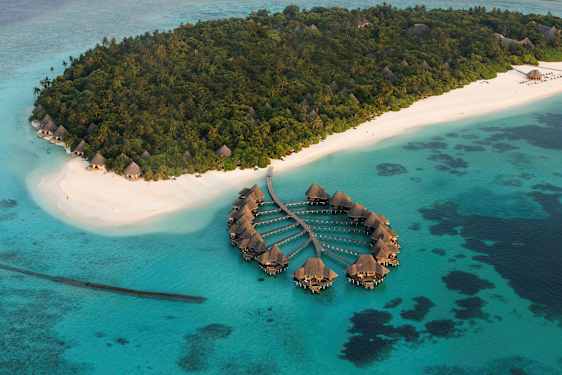 Luftfoto af en tropisk ø med hvide sandstrande og overnatningsvillaer. (AI-genereret tekst)