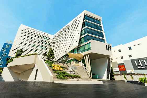 Moderne bygning med unik arkitektur, store glaspartier og en skrå facade. (AI-genereret tekst)