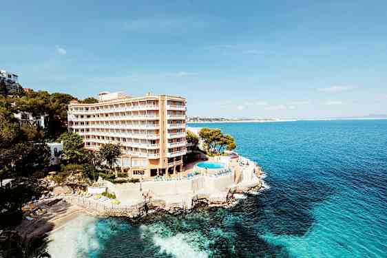 Hotel ved kysten med en pool og udsigt over havet. (AI-genereret tekst)