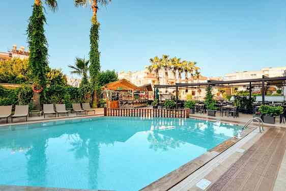 Udendørs pool med liggestole, træer og en bar i baggrunden. (AI-genereret tekst)