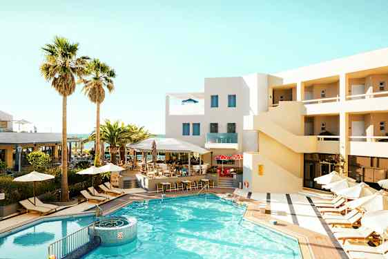 En udendørs swimmingpool omgivet af liggestole og parasoller ved et hotel med beige facade. (AI-genereret tekst)