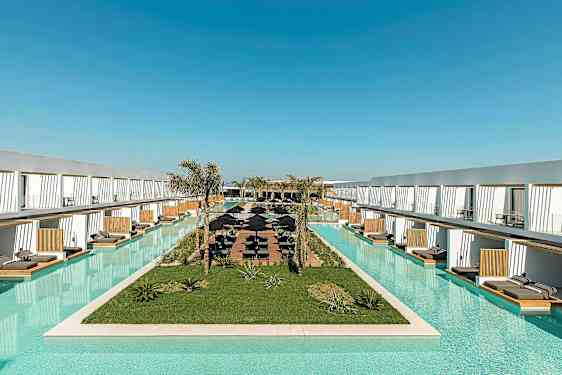 Lang pool omgivet af moderne hotelkompleks med liggestole. (AI-genereret tekst)