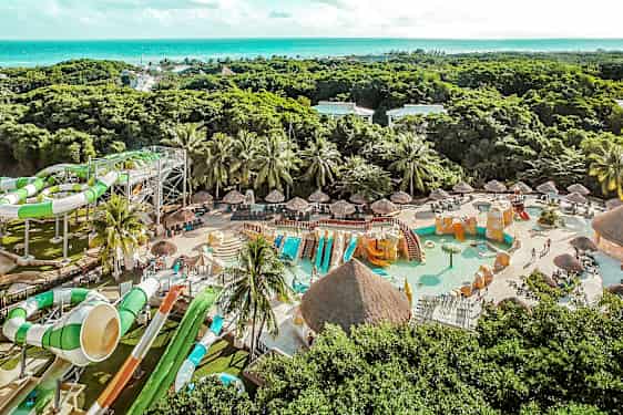 Et billede af en vandpark med vandrutsjebaner, swimmingpools og grønne omgivelser i baggrunden. (AI-genereret tekst)