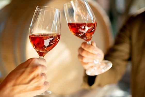 To glas med rosévin løftes op. (AI-genereret tekst)