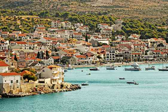 En kystby med huse tæt på vandkanten og både i bugten. (AI-genereret tekst)