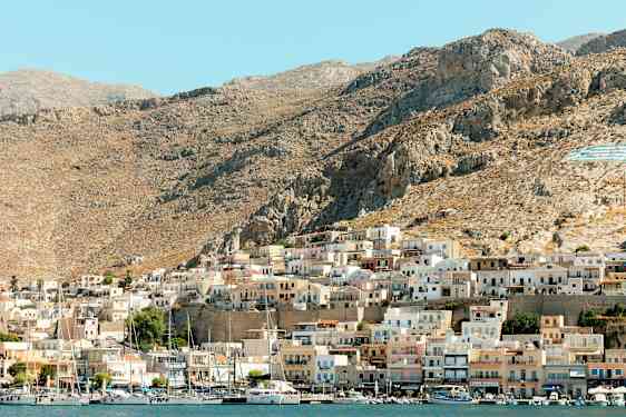 En kystby med små huse på en bjergskråning. (AI-genereret tekst)