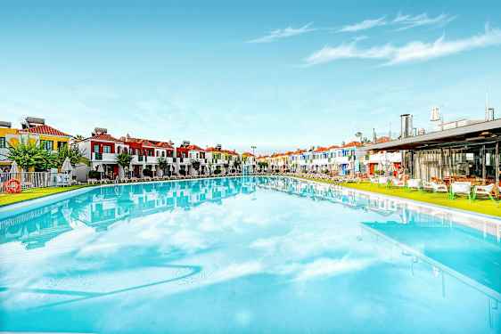 Stor pool med farverige bygninger i baggrunden. (AI-genereret tekst)