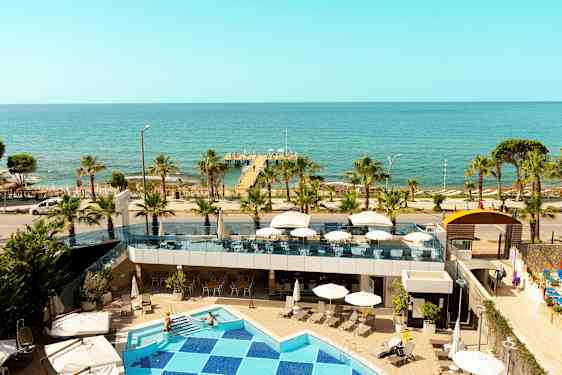 Udsigt fra hotellet mod havet med pool, terrasse og bro. (AI-genereret tekst)