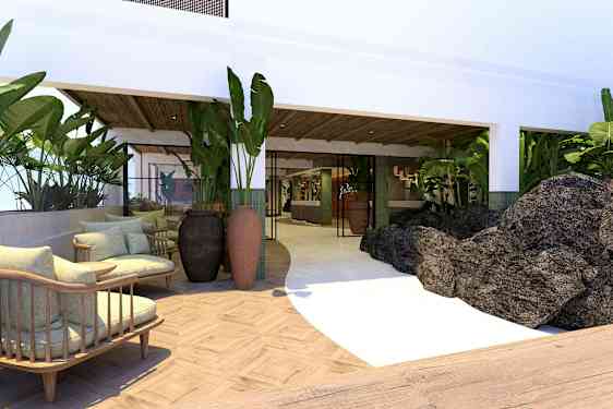 Et hotelområde med siddepladser, planter og sten. (AI-genereret tekst)