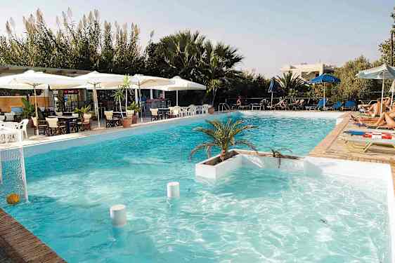 En swimmingpool med liggestole, parasoller og et serveringsområde i baggrunden. (AI-genereret tekst)