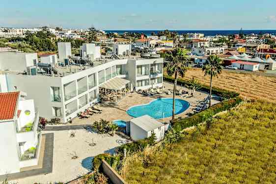 Luftfoto af hotelområde med swimmingpool og omkringliggende bygninger. (AI-genereret tekst)