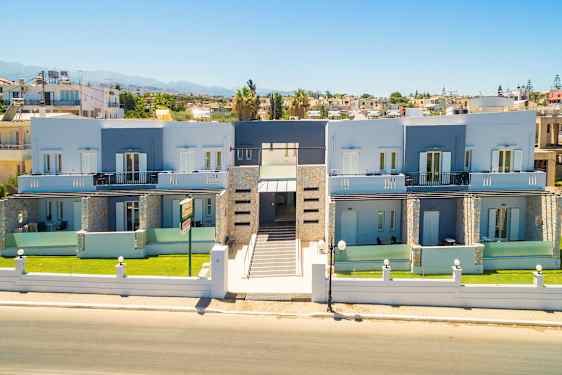 Billede af en modern bygning med to etager, omgivet af en have og med en central indgang som vender mod en gade. (AI-genereret tekst)