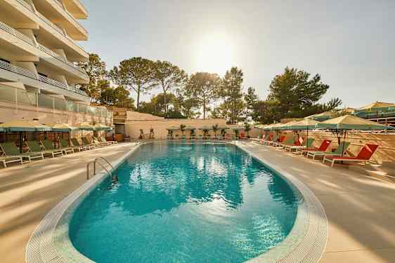 En udendørs pool med liggestole og parasoller i en solrig omgivelser. (AI-genereret tekst)