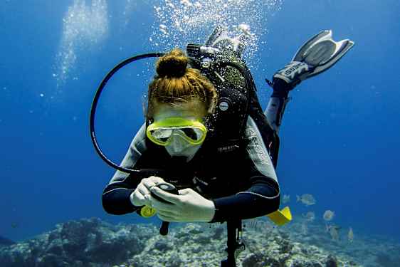 En person der dykker under vandet med dykkerudstyr og synlige luftbobler. (AI-genereret tekst)