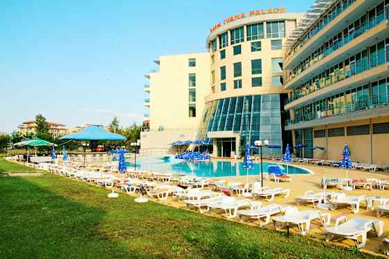 Hotellets poolområde med liggestole og parasoller. (AI-genereret tekst)