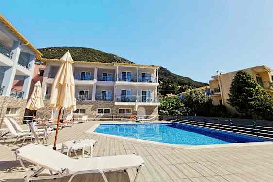 Billede af en udendørs pool med solsenge omkring, bag ses en bygning og vegetation. (AI-genereret tekst)