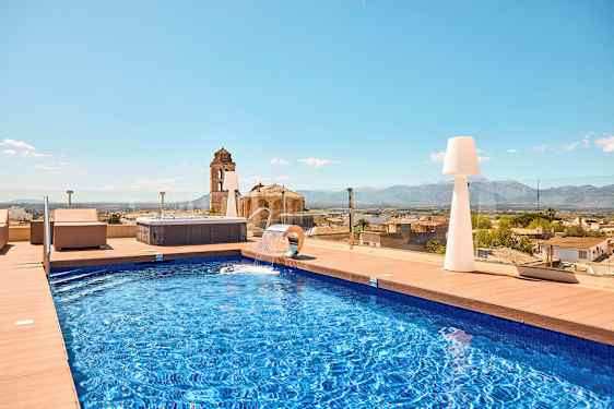 Udendørs swimmingpool med udsigt over byen og bjergene. (AI-genereret tekst)