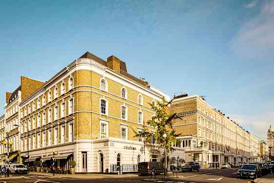 En gade med en række klassiske bygninger og parkerede biler. (AI-genereret tekst)