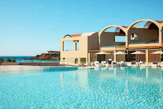 En swimmingpool ved et hotel med havet i baggrunden. (AI-genereret tekst)