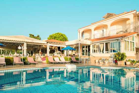 Udendørs område med hotel, swimmingpool og liggestole. (AI-genereret tekst)