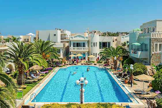 En pool omgivet af palmer, liggestole og bygninger under en klar blå himmel. (AI-genereret tekst)