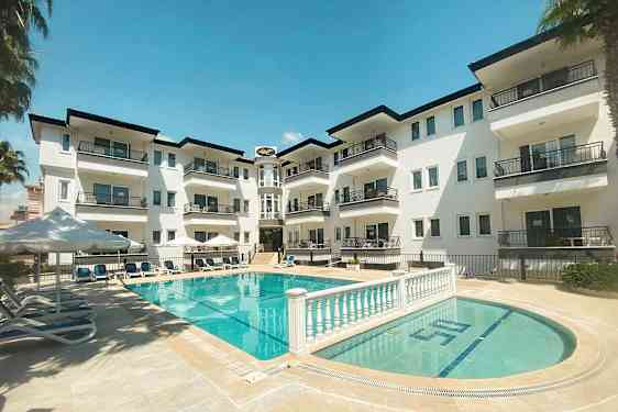 En lejlighedsbygning med altaner ud mod et poolområde. (AI-genereret tekst)