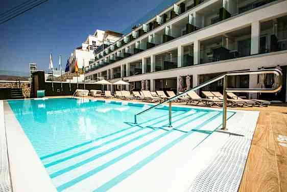 Udendørs pool ved hotel med solsenge og glasaltaner. (AI-genereret tekst)