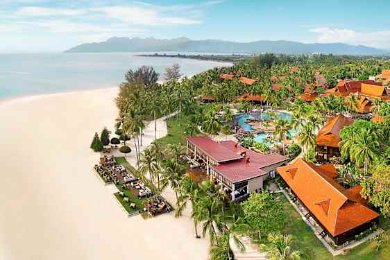 Strand med hvid sand ved siden af frodig resort med orange tage og poolområde. (AI-genereret tekst)