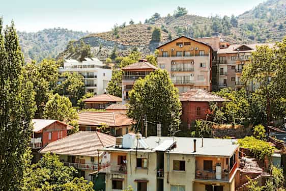 En samling boliger blandt træer ved en skråning. (AI-genereret tekst)