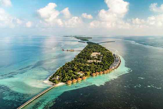 Luftfoto af en tropisk ø med villaer over vandet og turkis hav. (AI-genereret tekst)