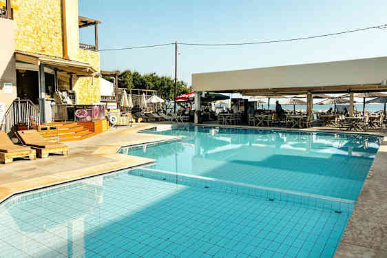 En pool med liggestole og en nærliggende café. (AI-genereret tekst)