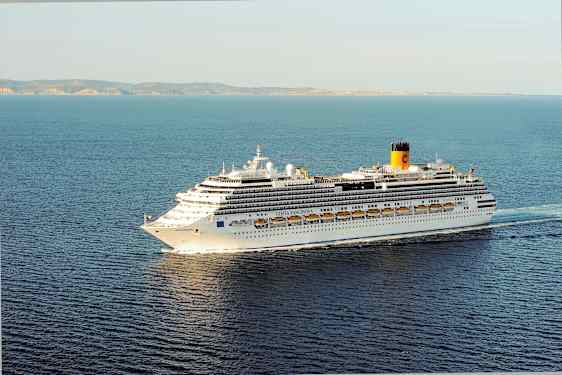 Et stort krydstogtskib på havet, med land i baggrunden. (AI-genereret tekst)