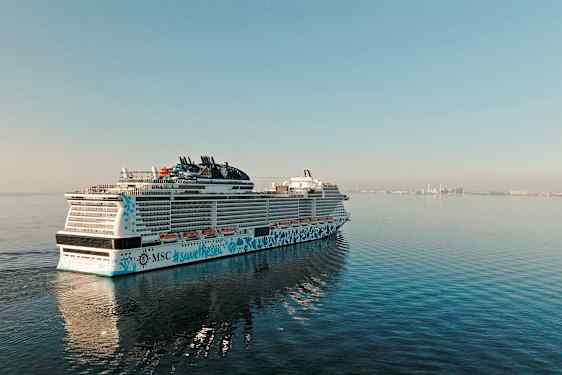 Et krydstogtskib på havet med en by i baggrunden. (AI-genereret tekst)