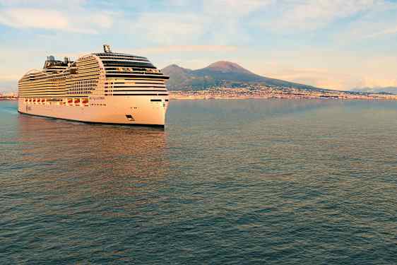 Et krydstogtskib sejler nær en kyst med bjerge i baggrunden. (AI-genereret tekst)