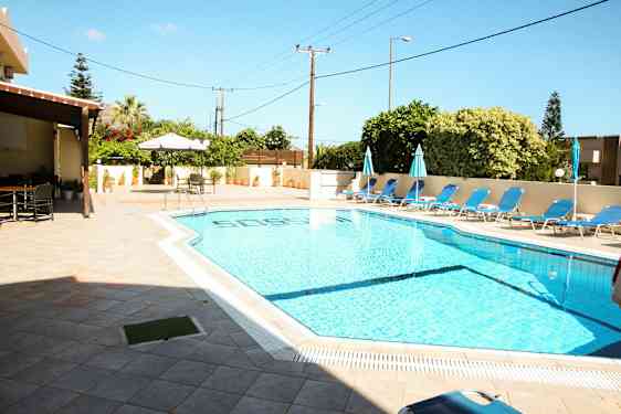 Udendørs pool med liggestole og parasoller ved siden af en terrasse. (AI-genereret tekst)