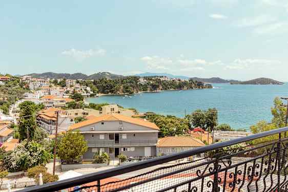 Udsigt over en kystby med røde tage og havet i baggrunden. (AI-genereret tekst)