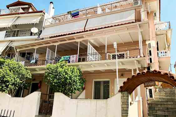 Et flerfamiliehus med flere altaner og tøj hængende til tørre. (AI-genereret tekst)