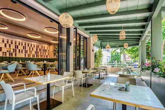 Moderne restaurant med udendørs og indendørs siddepladser. (AI-genereret tekst)