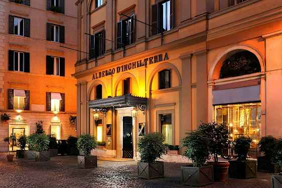 Et hotel med en arkade foran indgangen, oplyst om aftenen. (AI-genereret tekst)