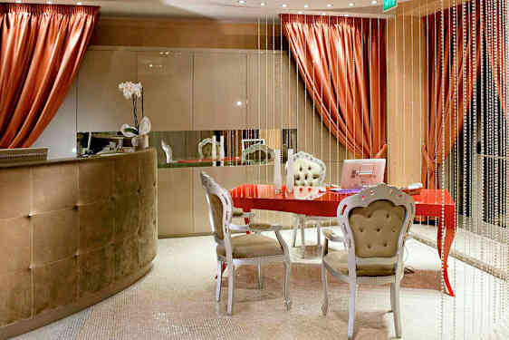 Et indbydende rum med et rødt bord, elegante møbler og dekorative elementer. (AI-genereret tekst)