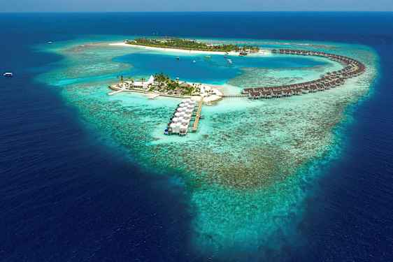 Luftfoto af en tropisk ø med overhavsbungalower og blå lagune omgivet af koralrev. (AI-genereret tekst)