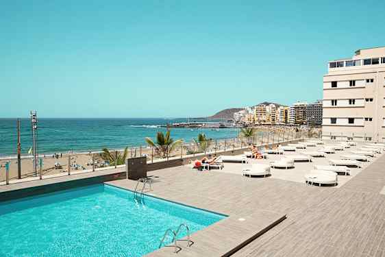 Udsigt over en pool og en strand med havet i baggrunden. (AI-genereret tekst)