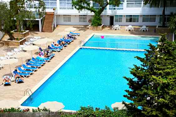 En hotelpool med liggestole, parasoller og mennesker, der nyder solen. (AI-genereret tekst)