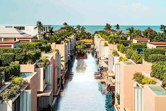 En udsigt over et moderne feriekompleks med swimmingpools og grønne områder. (AI-genereret tekst)