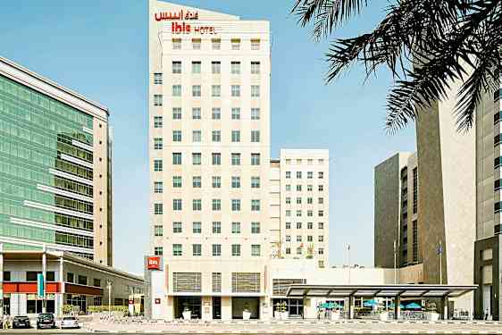 En hotelbygning med moderne design i et byområde, omgivet af andre bygninger. (AI-genereret tekst)