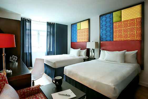 Hotelværelse med to senge, moderne møbler og dekorative elementer. (AI-genereret tekst)