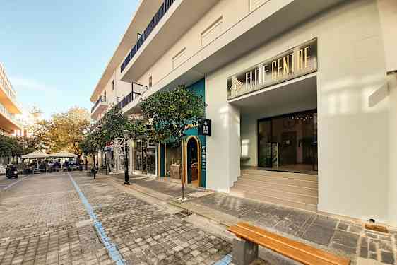 Et gademotiv med butikker og caféer langs en brolagt promenade. (AI-genereret tekst)