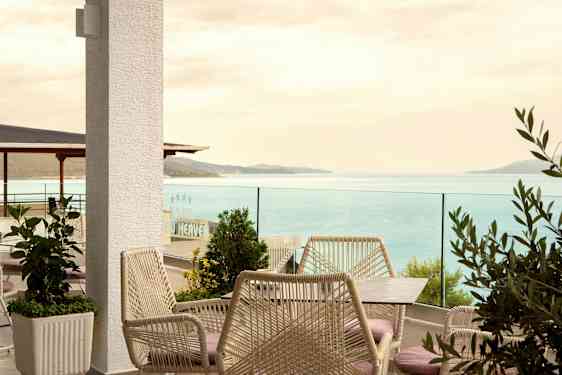 En terrasse med havemøbler og udsigt over havet. (AI-genereret tekst)